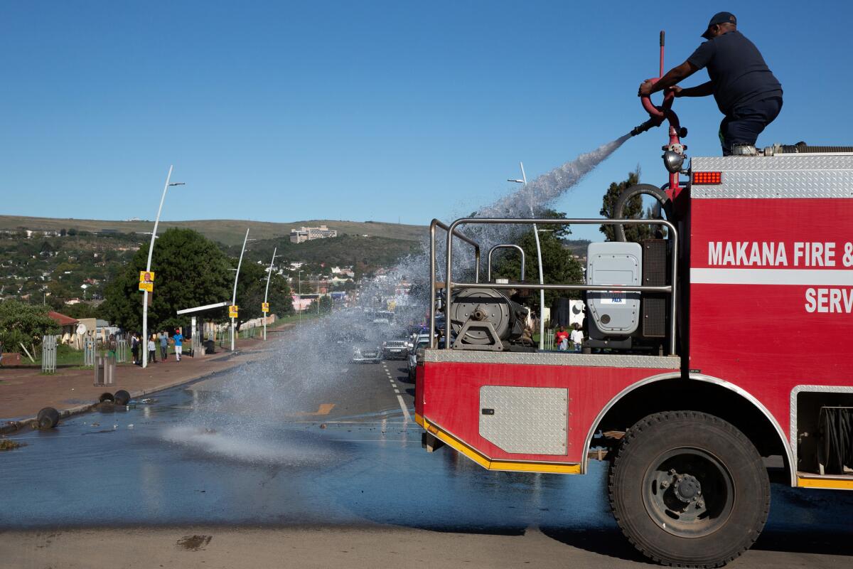 A fire brigade washes away feces that was dumped on the main road ahead of President Cyril Ramaphosa's visit to Makhanda on Freedom Day.