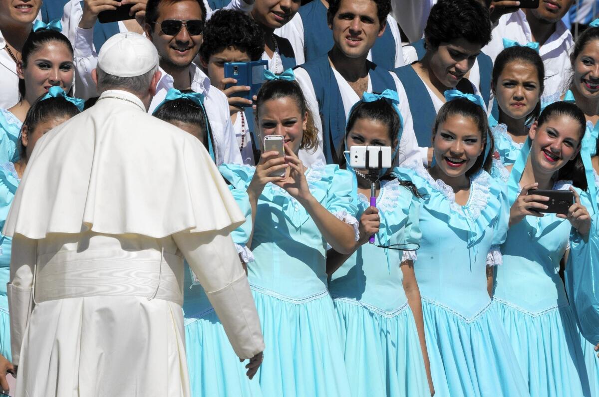 Dancers from Argentina take pictures of Pope Francis in August after his weekly general audience in St. Peter's Square at the Vatican.