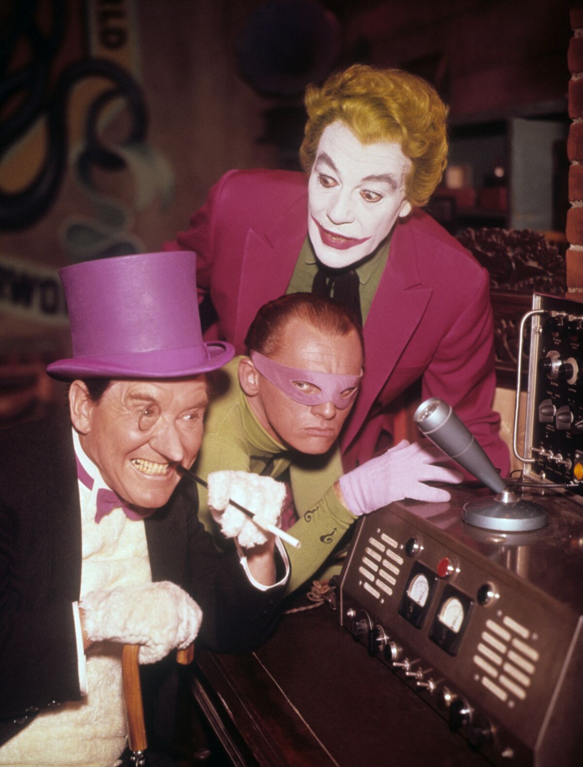 A man in a tophat, a man with an eye mask and a man in clown makeup