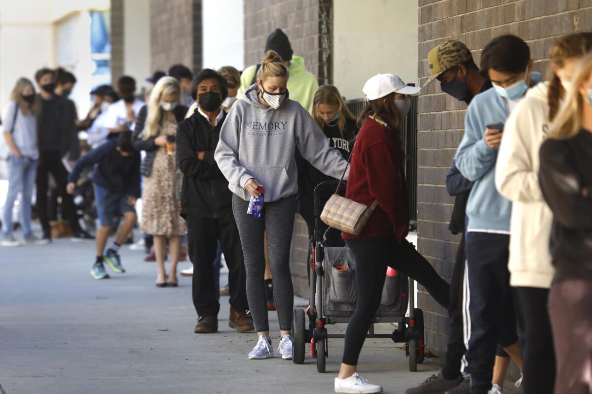 People wearing masks stand in line.