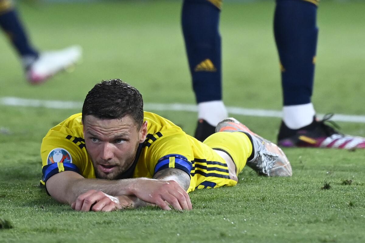 Sweden's Marcus Berg lies on the pitch during the Euro 2020 soccer championship group E match between Spain and Sweden at La Cartuja stadium in Seville, Monday, June 14, 2021. (AP Photo/Pierre Philippe Marcou, Pool)