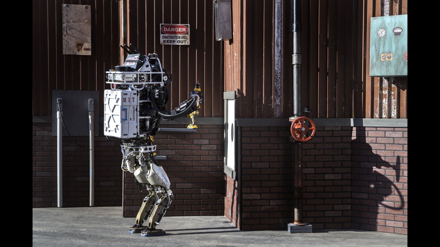 The MIT team's robot lifts a drill during the DARPA Robotics Challenge in Pomona.