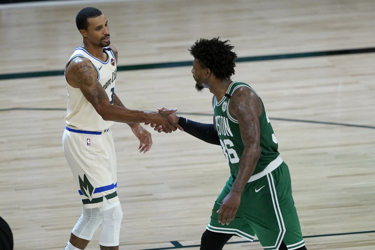 Milwaukee Bucks' George Hill, left, and Boston Celtics' Marcus Smart shake hands following an NBA basketball game Friday, July 31, 2020, in Lake Buena Vista, Fla. (AP Photo/Ashley Landis, Pool)