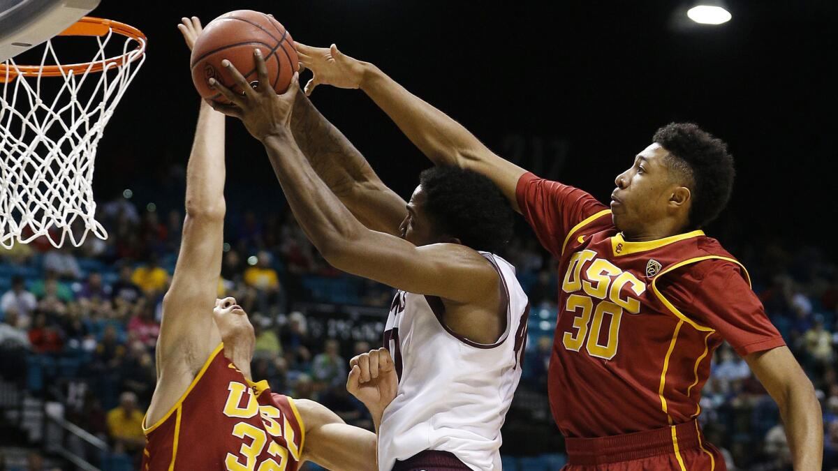 USC forward Nikola Jovanovic, left, and guard Elijah Stewart, right, try to block a shot by Arizona State's Shaquielle McKissic during a Pac-12 tournament game last season.