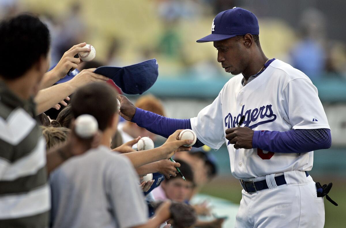 Kenny Lofton signs an autograph for fan before a game