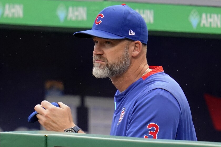 FILE - Chicago Cubs manager David Ross stands in the dugout during the first inning of a baseball game against the Pittsburgh Pirates in Pittsburgh, Wednesday, May 26, 2021. Chicago Cubs manager David Ross and the team agreed Friday, March 11, 2022, to a contract extension through the 2024 season that includes a club option for 2025. (AP Photo/Gene J. Puskar, File)