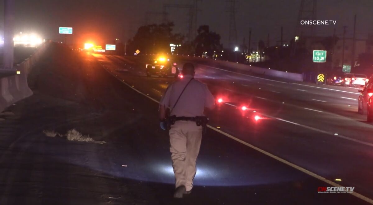 A California Highway Patrol officer walks along the scene of a fatal pedestrian crash Friday night on I-5 in National City.