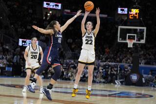 Iowa guard Caitlin Clark (22) shoots a three-point basket over UConn guard Nika Muhl.