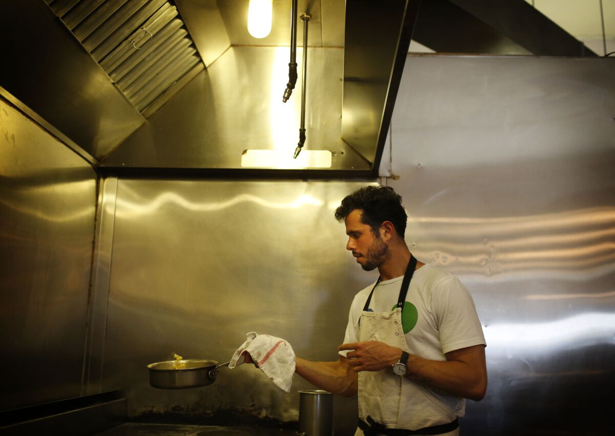 Ari Taymor cooks in the kitchen of Alma, his tiny downtown L.A. restaurant, which closed at the end of October.
