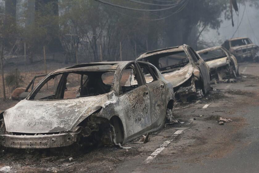 ADVANCE FOR PUBLICATION ON THURSDAY, APR. 25, AND THEREAFTER - FILE - This Nov. 9, 2018, file photo the burned out hulks of cars abandoned by their drivers sit along a road in Paradise, Calif. The scale of disaster in the Camp Fire was unprecedented, but the scene of people fleeing wildfire was familiar, repeated numerous times over the past three years up and down California from Redding and Paradise to Santa Rosa, Ventura and Malibu. (AP Photo/Rich Pedroncelli, File)