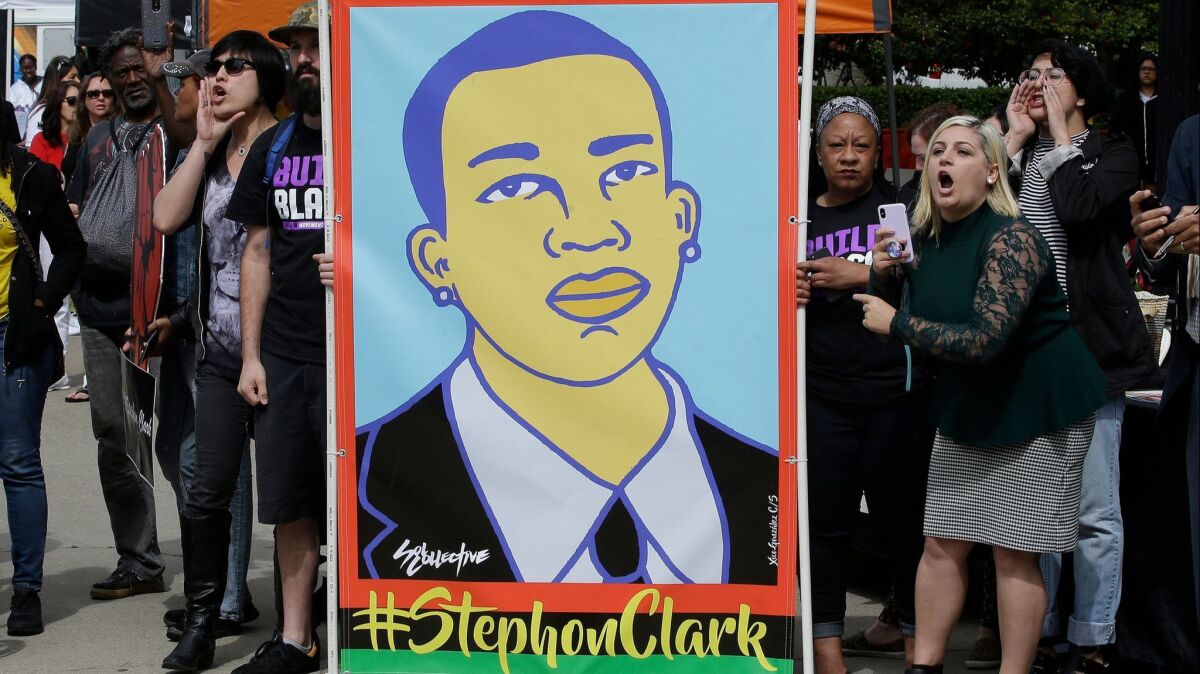Protesters display an image of Stephon Clark at a crime victims rights rally.