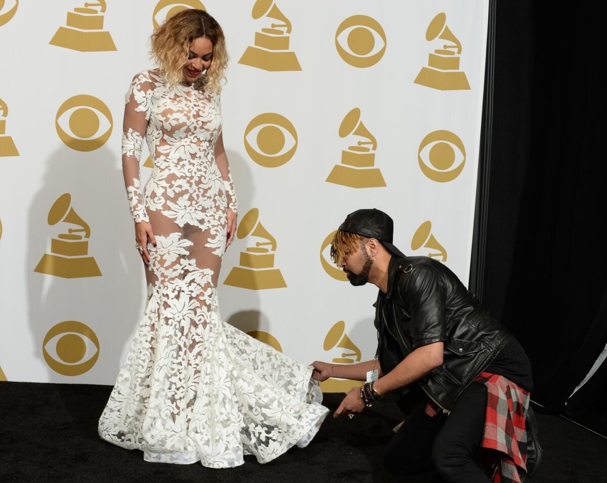 Beyonce gets some help arranging her gown in the press room at the 56th Grammy Awards.