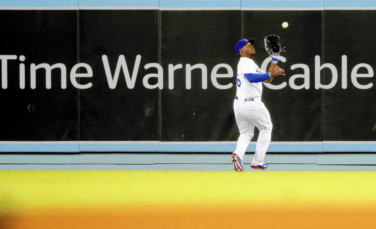 Dodgers outfielder Yasiel Puig makes a catch at Dodger Stadium this month during a game against the Angels. Most Dodgers fans have been unable to watch the team play on TV because of a pay dispute between Time Warner Cable and other pay-TV operators.