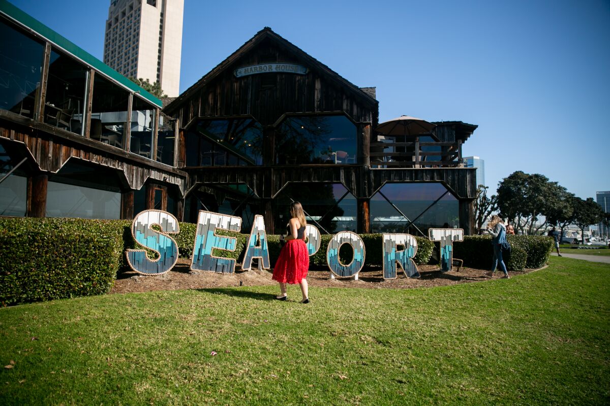 Visitors pose for photos in front of a new sign installed at Seaport Village. Parts of Seaport Village are currently under renovation.