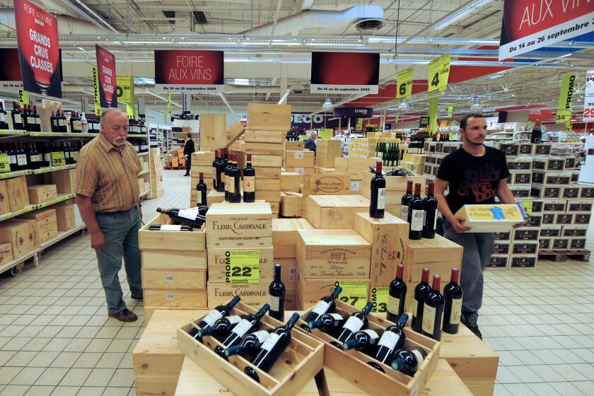 TO GO WITH AFP STORIES IN FRENCH AND IN ENGLISH BY SUZANNZ MUSTACICH: "US BORDEAUX PRICES AT TRISK OF BLOODBATH, EXPERTS SAY". (FILES) A picture taken on September 14, 2009 shows people buying wine at a supermarket in Strasbourg, eastern France. Even as Chateau Lafite leads a surge for Bordeaux vintners in Asia, US retail prices for the same wines have skidded below wholesale cost as a major importer dumps stocks worth tens of millions of dollars. AFP PHOTO / PATRICK HERTZOG (Photo credit should read PATRICK HERTZOG/AFP via Getty Images)