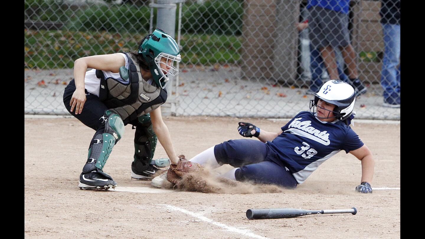 Providence's Sarah Cox tags out St. Genevieve's Natalia Pilpil at home in a non-league softball game at Olive Park in Burbank on Friday, March 9, 2018.