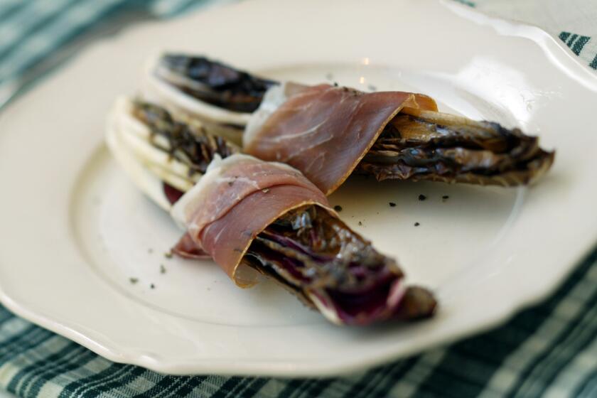 Radicchio is grilled then wrapped with prosciutto. Recipe: Grilled radicchio and prosciutto.