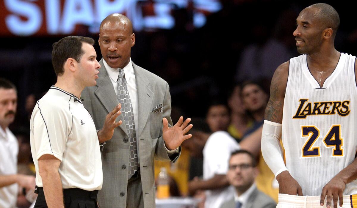 Lakers Coach Byron Scott and guard Kobe Bryant talk to referee Brian Forte before the start of overtime against the Raptors.