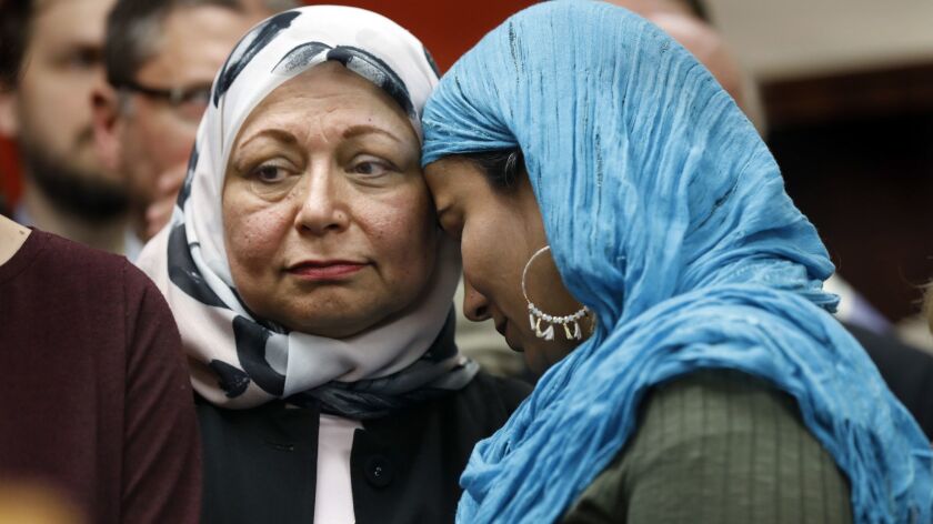 Najeeba Syeed, right, rests her head on Hedab Tarifi, both members of the Islamic Center of Southern California. People of all faiths came together in prayer a day after attacks on mosques in New Zealand killed at least 49 people.