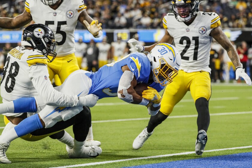 Chargers running back Austin Ekeler (30) dives into the end zone between Steelers Taco Charlton (98) and Tre Norwood (21).