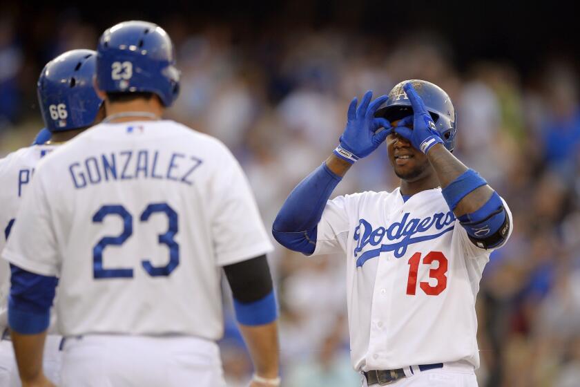 Dodgers shortstop Hanley Ramirez, right, gestures to teammates Yasiel Puig, left, and Adrian Gonzalez after hitting a three-run home run during the first inning of Saturday's 4-3 victory over the Philadelphia Phillies.
