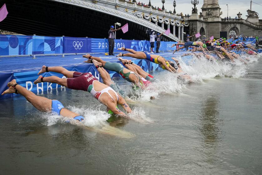Athletes dive into the water for the start of the women's individual triathlon competition.