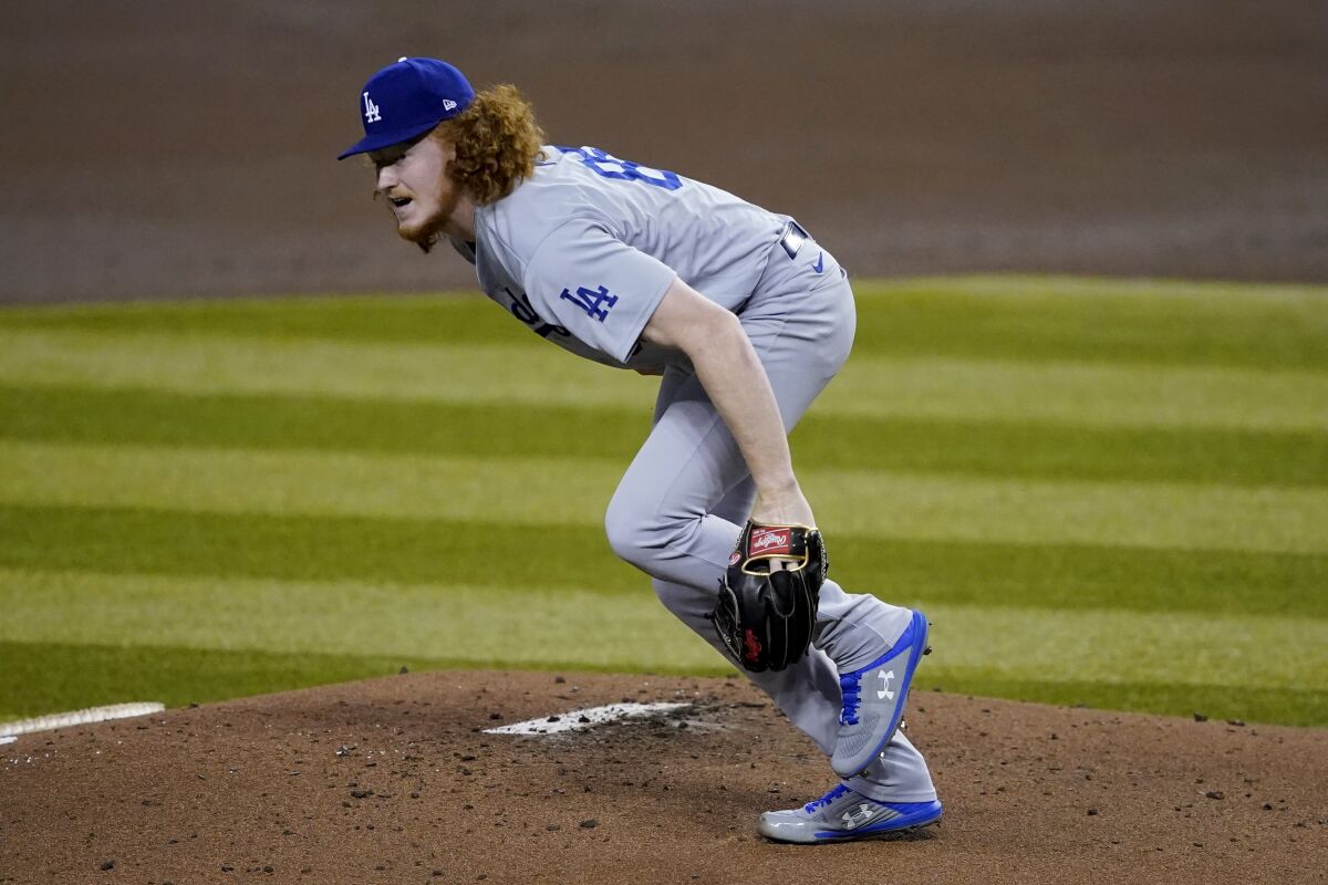 Dodgers starting pitcher Dustin May gets up after taking a comebacker off his foot.