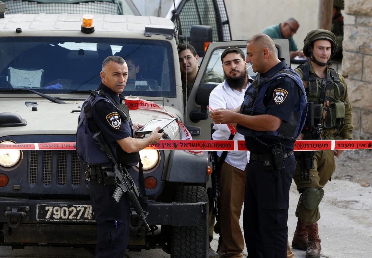 Israeli security forces and settlers gather near the sealed off scene of what the Israeli military said was a stabbing attack in the West Bank city of Hebron on Saturday.
