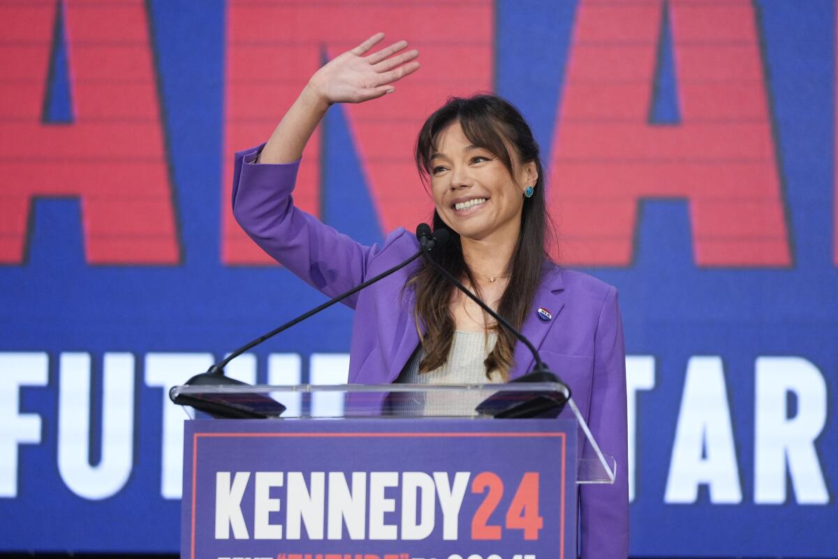 Nicole Shanahan  waves from podium that reads "Kennedy 24"