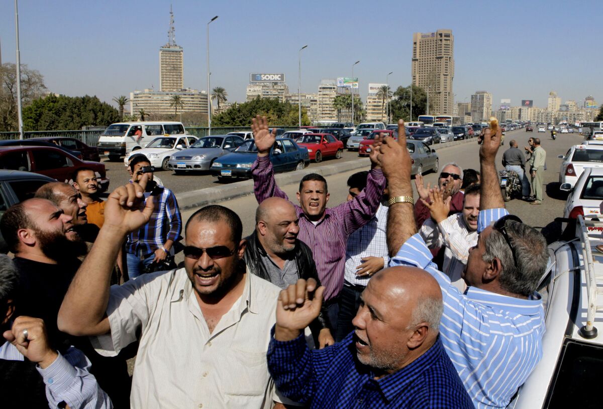 Egyptian taxi drivers shout slogans against President Mohammed Morsi as they block part of the 6th of October bridge in central Cairo.