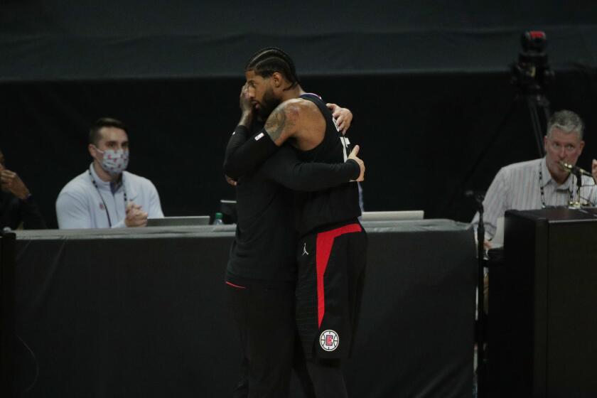 Clippers forward Paul George and coach Tyronn Lue embrace in the final moments of the season-ending loss to the Phoenix Suns.