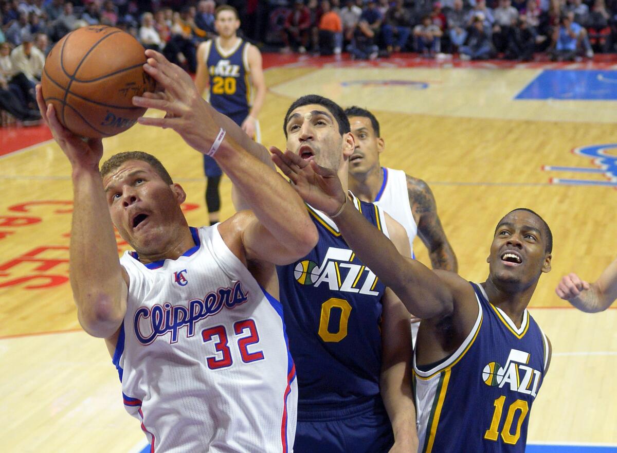 Clippers forward Blake Griffin, left, grabs a rebound away from Utah's Enes Kanter, center, and Alec Burks on Monday night.