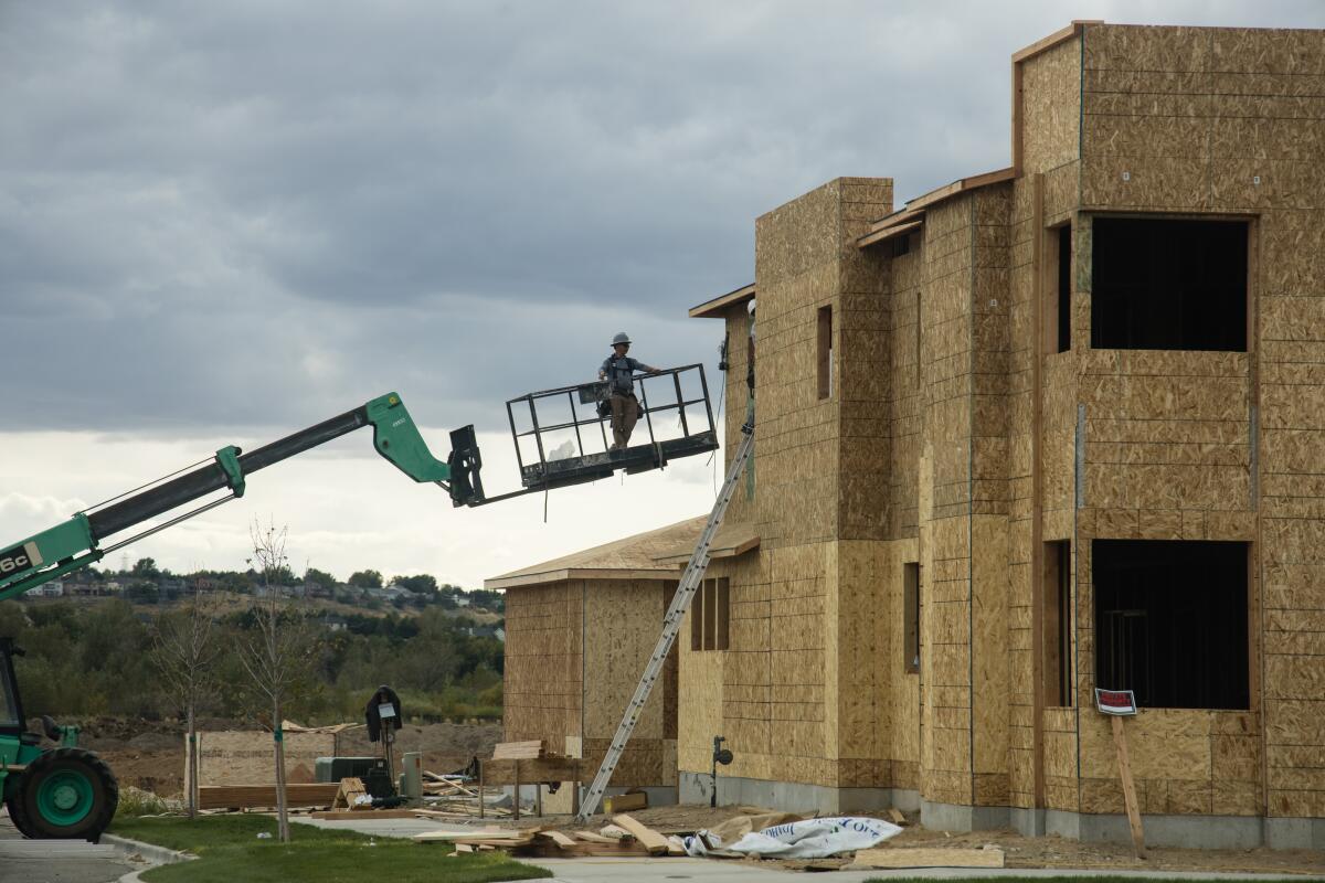 A crew member is lifted on a crane to work on a structure being built in Boise, Idaho.