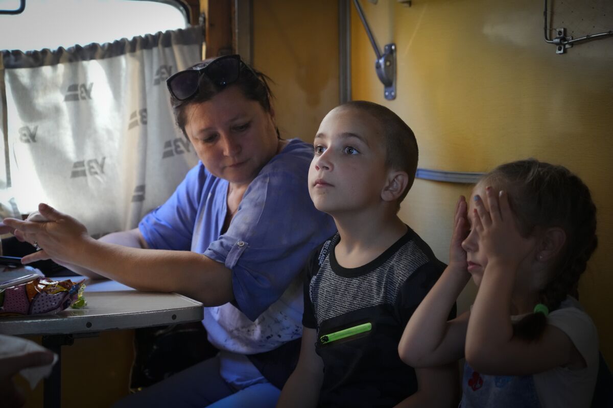 People evacuated from the war hit area sit inside an evacuation train waiting for departure in Pokrovsk, eastern Ukraine, Saturday, June 11, 2022. (AP Photo/Efrem Lukatsky)