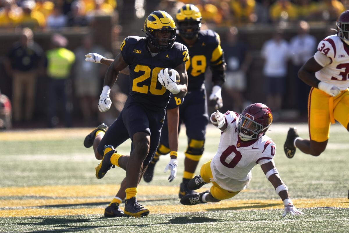 Michigan running back Kalel Mullings (20) runs for a 53-yard touchdown as USC safety Akili Arnold dives in vain for a tackle.