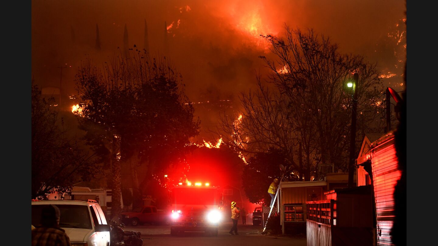 Firefighters try to protect homes from the Thomas fire along Highway 33 in Casitas Springs.