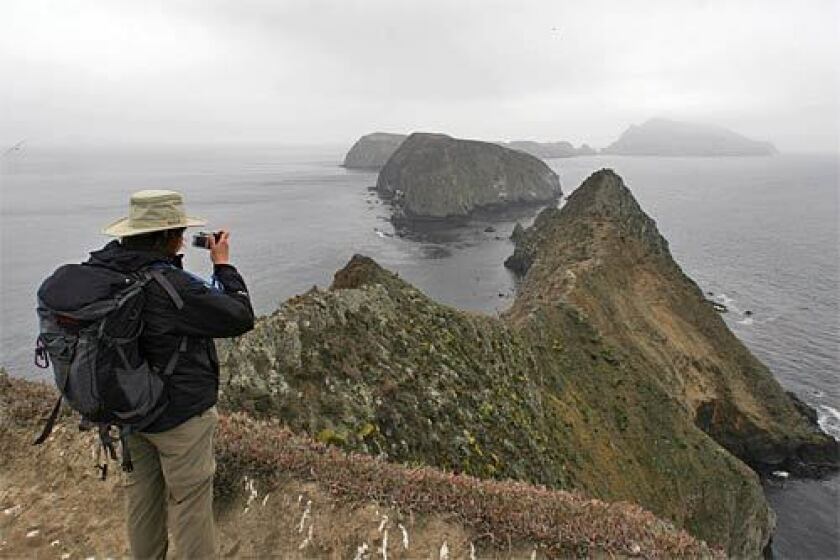 A hiker captures the view for posterity from Inspiration Point on East Anacapa Island. Sixteen miles southwest of Ventura, Anacapas three volcanic islets rise steeply from the sea. The islets seem to float on the horizon like a distant mirage. The name, in fact, is derived from a Chumash word for mirage.