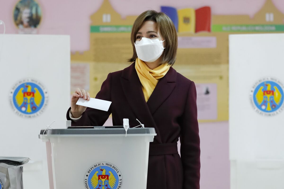 Former prime minister Maia Sandu prepares to cast her vote in the country's presidential election runoff in Chisinau, Moldova, Sunday, Nov. 15, 2020. Moldovans returned to the polls Sunday for the second round of voting in the country's presidential election, facing a choice between the staunchly pro-Russian incumbent Igor Dodon, and his popular pro-Western challenger, former prime minister Maia Sandu. (AP Photo/Roveliu Buga)