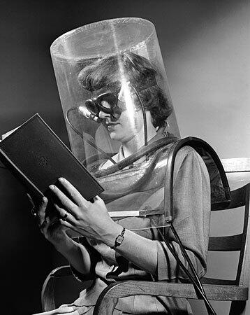Betty Cook, a lab assistant at the Stanford Research Institute, is shown taking a "blink test" as part of a project to track down smog in Stanford, Calif. on April 27, 1949. The test gauges eye irritation through photoelectric cells that record each blink of the eyes. The plastic helmet is filled with measured amounts of smog. Cook wears glassless goggles that act as blink recorders. She reads a book to give uniform reaction conditions.The smog project is being conducted by the Air and Water Pollution Laboratory of the Western Oil and Gas Assn.
