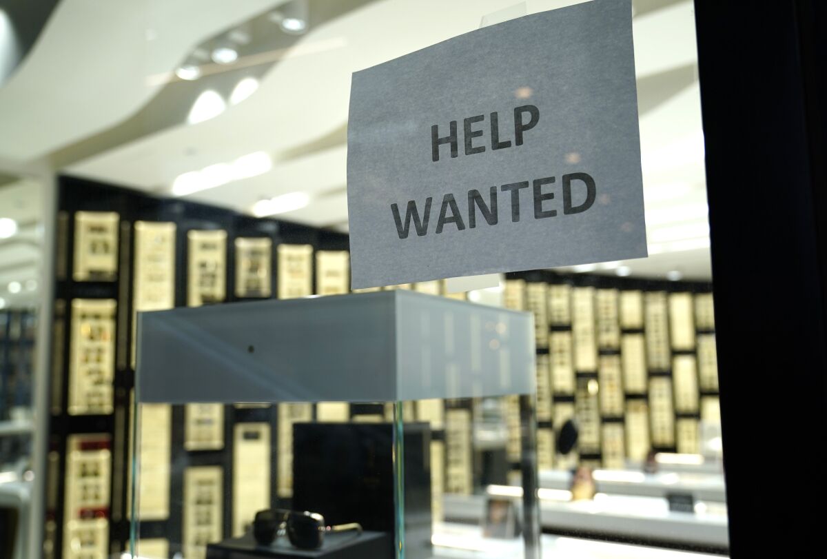 A Help Wanted sign is posted at a Designer Eyes store