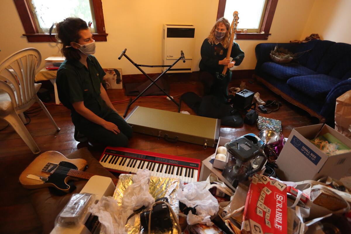 Musicians Georgina Hahn, left, and Veronica Lorenzini, both 24, pack up their Echo Park apartment