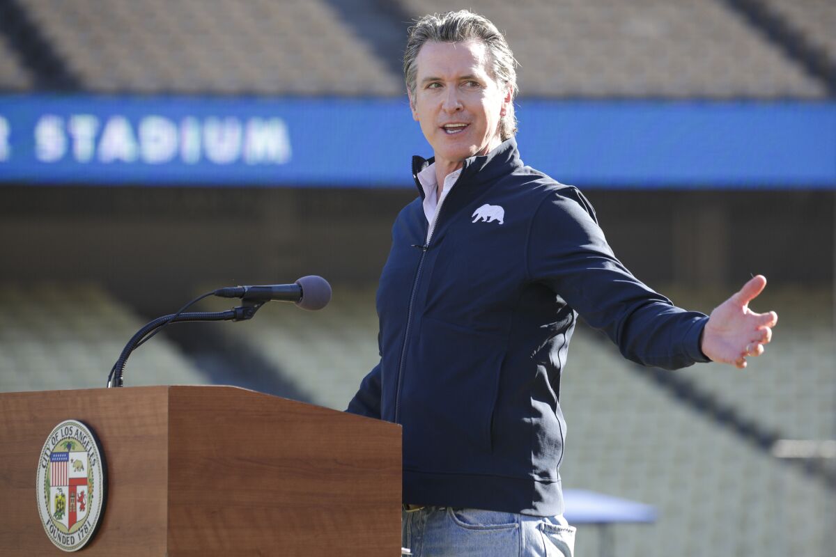 Gov. Gavin Newsom addresses a news conference at the launch of a mass COVID-19 vaccination site at Dodger Stadium.