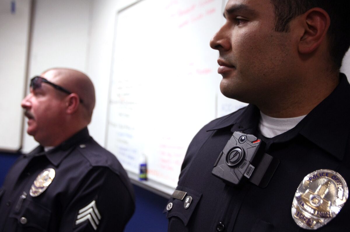 Los Angeles Police Officer Mendoza, right, wears a Taser Axon clip-on camera on his collar at a January news conference regarding the new on-body cameras that were tested within the department.