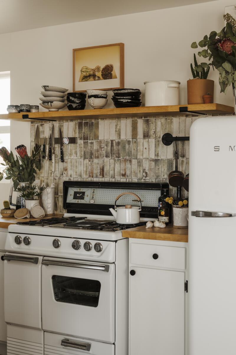 A vintage white stove and refrigerator and gray ceramic backsplash