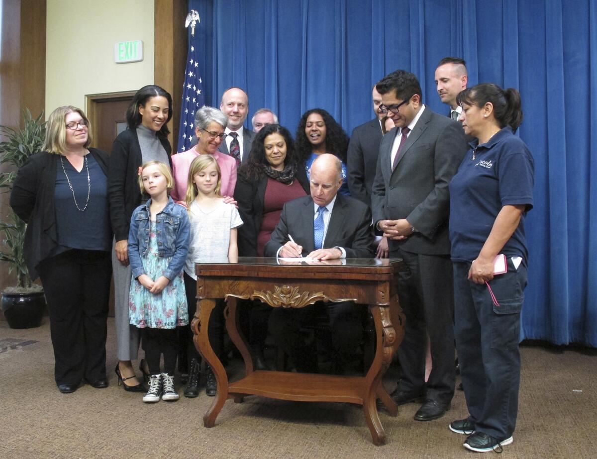 California Gov. Jerry Brown signs into law a measure increasing the amount of income Californians can receive during the state's existing six weeks of paid family leave in Sacramento, Calif. on April 11.