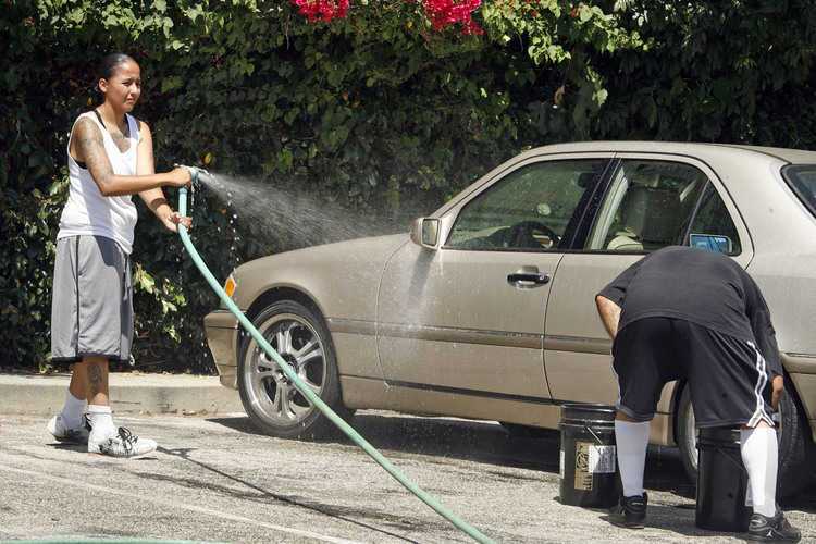 Rosa Cardenas, left, helps wash cars with other friends and family of Marvin Laguan who was shot and killed last Monday. Loved ones held a car wash event on Altadena Dr. and Villa St. in Pasadena on Saturday, August 27, 2011. All funds will be used for Laguan's funeral expenses.