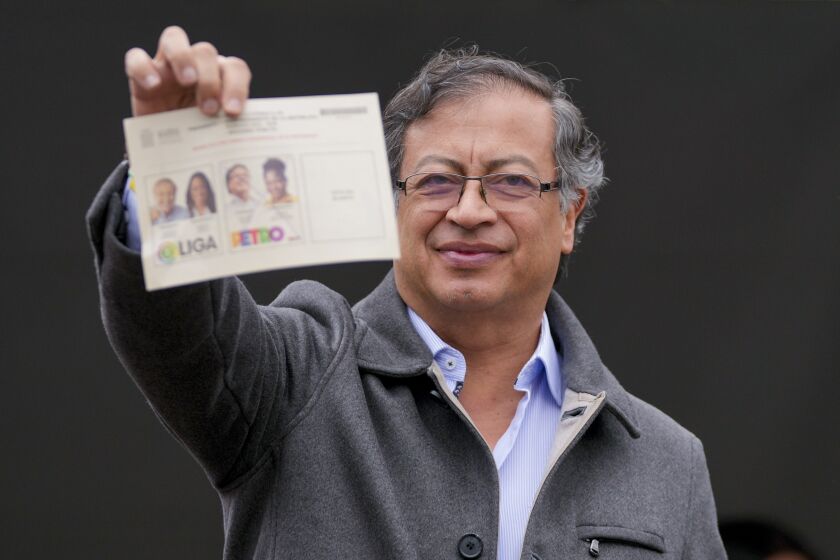 Gustavo Petro, presidential candidate with the Historical Pact coalition, shows his ballot before voting in a presidential runoff in Bogota, Colombia, Sunday, June 19, 2022. (AP Photo/Fernando Vergara)