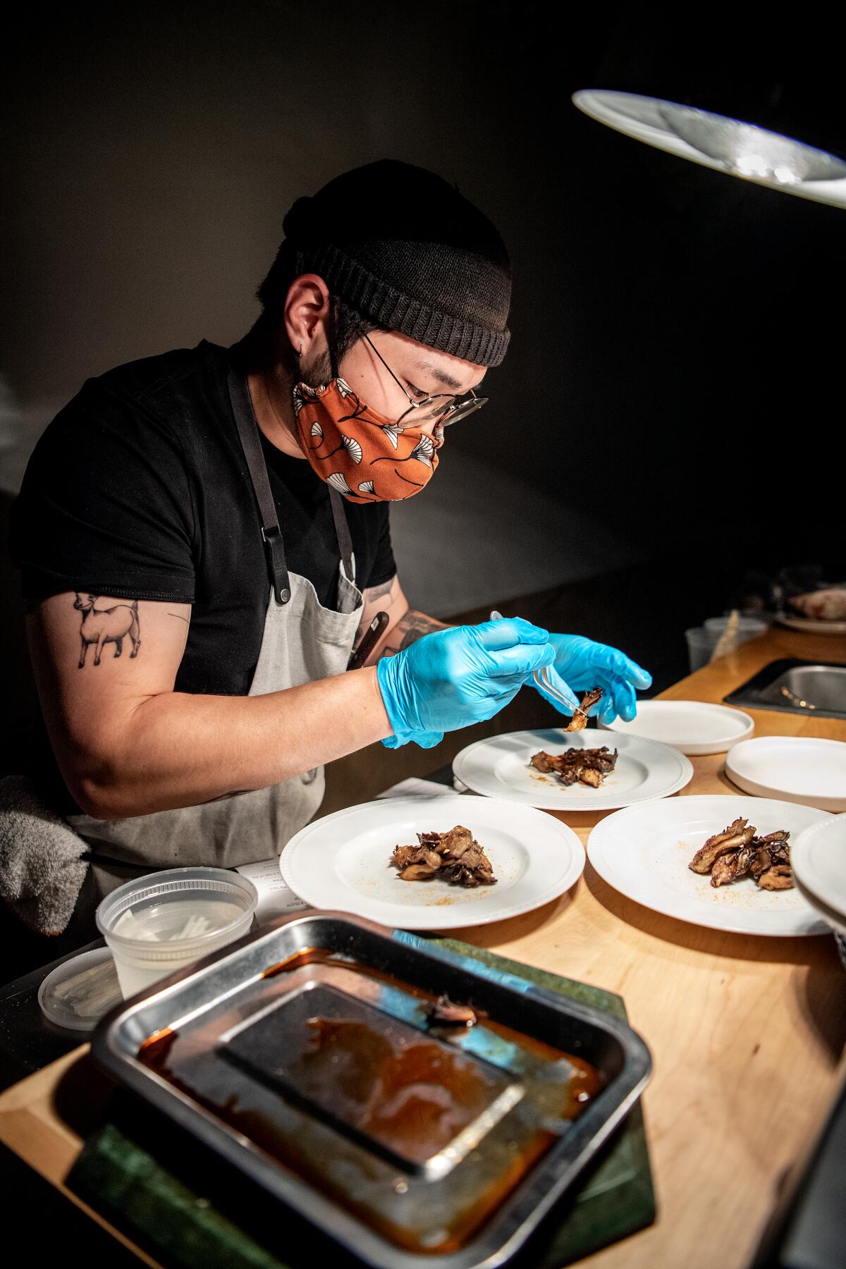 Chef/co-owner Ki Kim prepares dishes during service at his restaurant, Kinn.