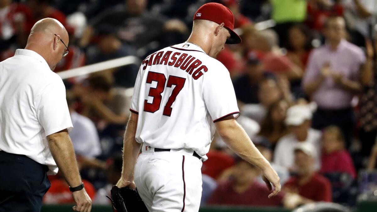Nationals starter Stephen Strasburg exits the game Wednesday in the third inning because of pain in the back of his right elbow.