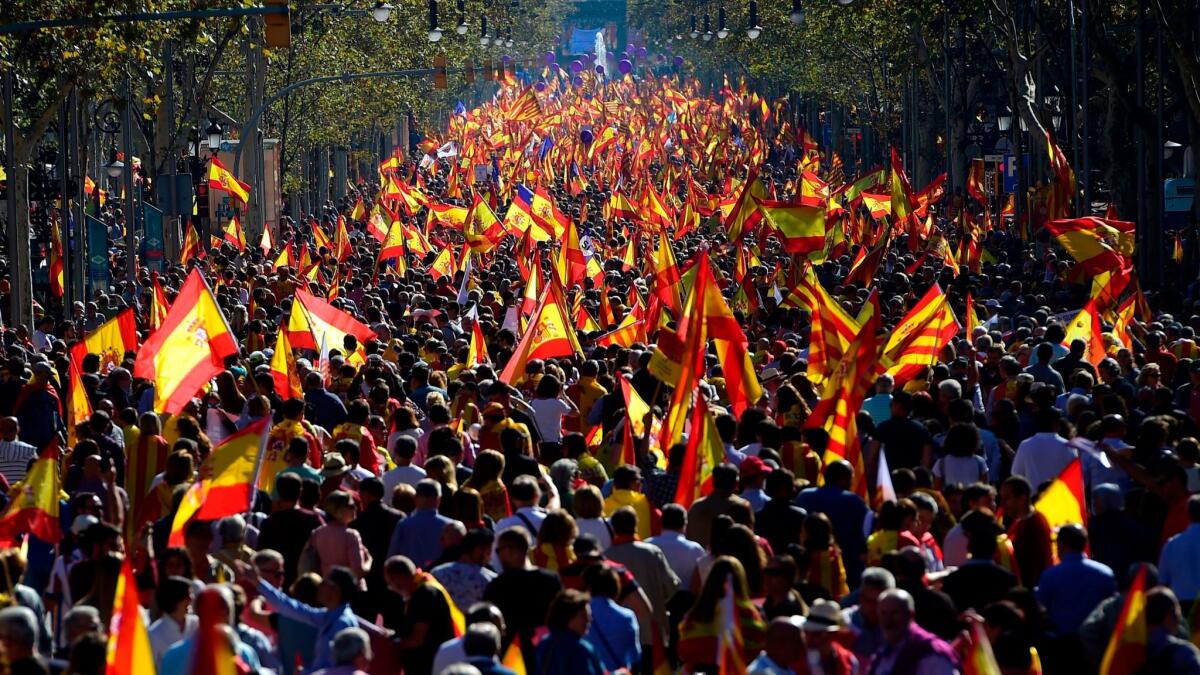 Marchers flood the streets in Barcelona, waving Spanish and Catalan Senyera flags in a pro-unity demonstration on Sunday.
